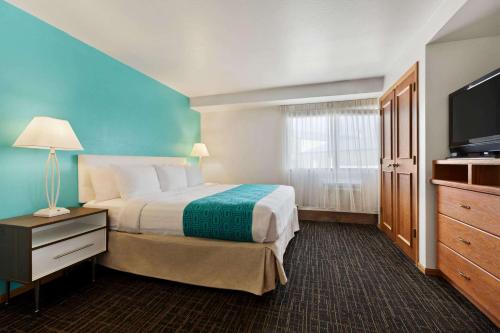 a hotel room with a bed and a flat screen tv at Howard Johnson by Wyndham Billings in Billings