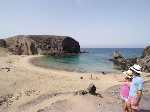 a man and a woman standing on a beach at Sandos Papagayo in Playa Blanca