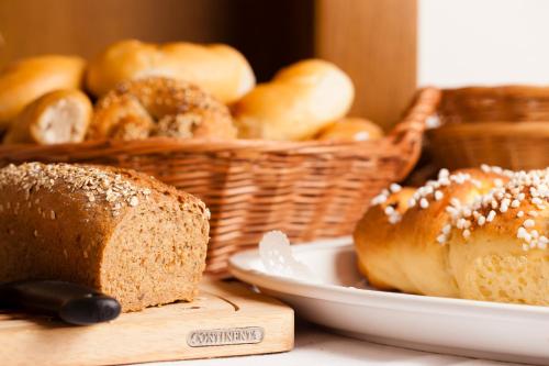 a table with a plate of bread and baskets of buns at Schottenhof in Fulpmes