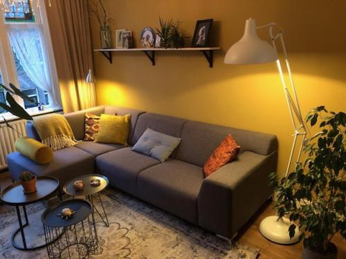 
a living room with a couch, coffee table and a lamp at Juuls B&B in Delft
