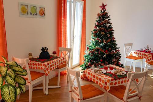 a dining room with a christmas tree in the corner at Zenzero e Limone in Siracusa