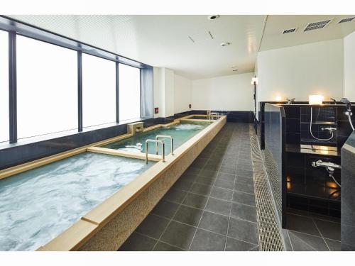 a large swimming pool in a hotel room at Hotel Lumiere Grande Nagareyama-Otakanomori in Nagareyama