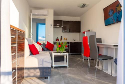 a living room with a white couch and red pillows at Apartmani Dalmacjia in Grebaštica
