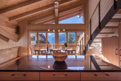 a large kitchen with a dining room with a large window at Chalet Aquila 8 Penthouse in Wengen
