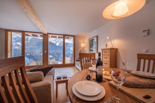 sala de estar con mesa, sofá y comedor en Chalet Roossi 3, en Wengen