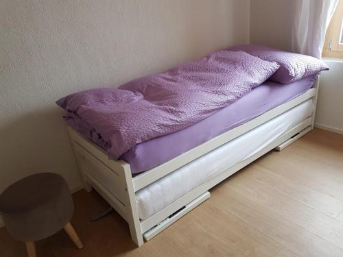a small bed in a room with a purple mattress at Chalet Grüneggli in Adelboden