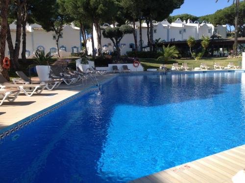 a blue swimming pool with lounge chairs and trees at Casa Soleada - Beautiful Villa, Best Corner by Pools, Resort Facilities,Full Kitchen, 3 Terraces, Internet in Marbella