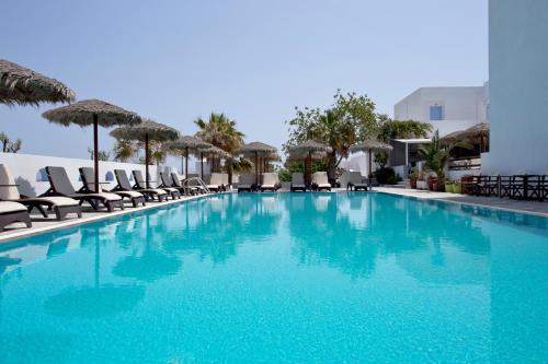 una piscina con sillas y sombrillas en un hotel en Alexandra Hotel en Kamari