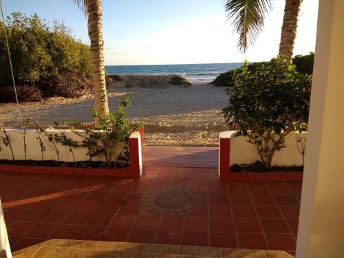 a view of the beach from the porch of a house at Drake Inn in Puerto Villamil