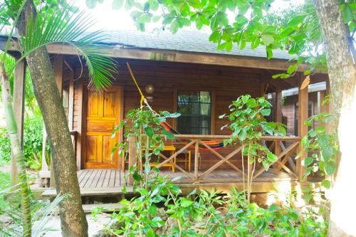 a house with a wooden door and a porch at Las Rocas Resort and Dive Center in West Bay