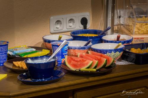 a counter with bowls of fruit and drinks on it at Haus am Lift in Kappl