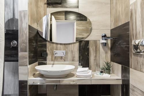 La salle de bains est pourvue d'un lavabo et d'un miroir. dans l'établissement Patrizia Romana Palace, à Rome