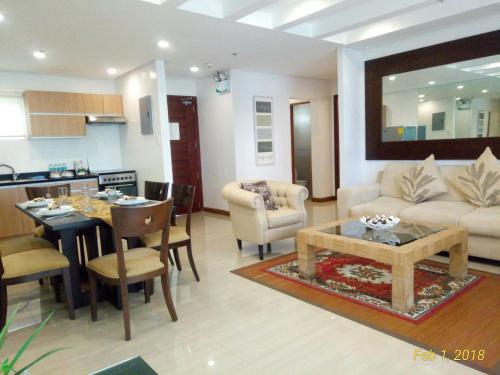 ein Wohnzimmer mit einem Sofa und einem Tisch sowie eine Küche in der Unterkunft Centtro Residences in Los Baños