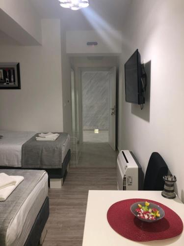 a room with two beds and a table with a bowl of fruit at Mark's Palace in Nikšić