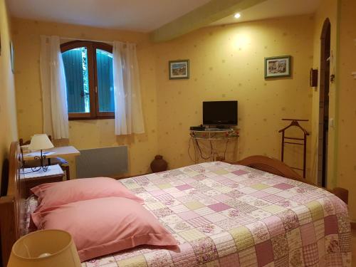 1 dormitorio con 1 cama y TV en Casa das Oliveiras, en Flassans-sur-Issole