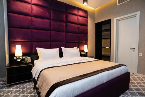 ein Schlafzimmer mit einem großen Bett mit rotem Kopfteil in der Unterkunft Gallery Art Hotel in Tbilisi City