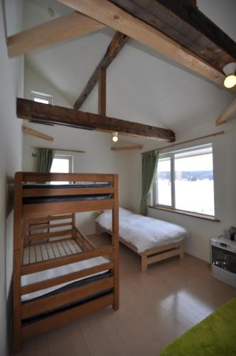 a bedroom with two bunk beds and a large window at Gufo no Mori Kamifurano in Kami-furano