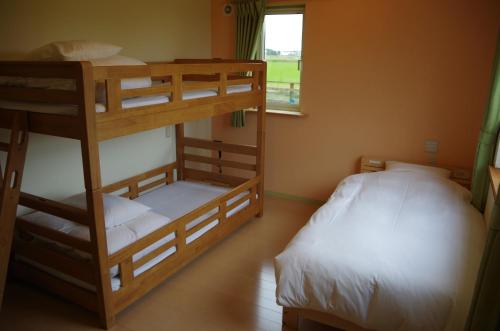 a bedroom with two bunk beds and a window at Gufo no Mori Kamifurano in Kami-furano