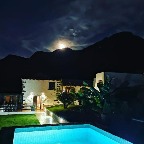 a view of a villa at night with the moon at Viña Camello in Buenavista del Norte