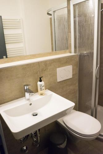 a bathroom with a sink and a toilet and a mirror at Am Wasserfall 31 in Bad Gastein
