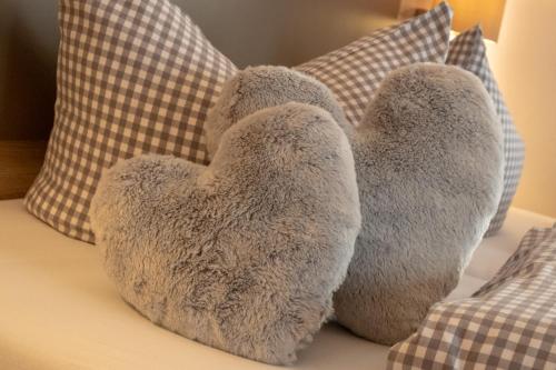 a stuffed bear sitting on a bed with pillows at Boutique Hotel Angerer in Murnau am Staffelsee