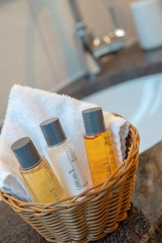 a basket with four bottles of moisturizers on a counter at Boutique Hotel Angerer in Murnau am Staffelsee