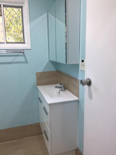 a bathroom with a sink and a mirror and a window at Elouera Units in Fraser Island