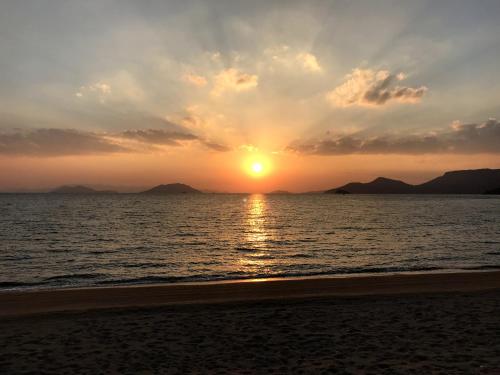 a sunset on the beach with the sun setting at Engawa in Tonosho