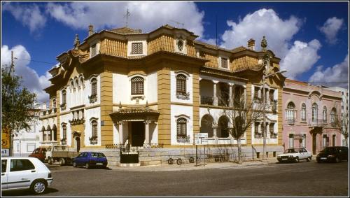 a large building with cars parked in front of it at Cantinho do Céu in Vila Real de Santo António