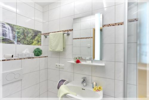 a white bathroom with a sink and a mirror at Gasthof BLASL Margaretha in Losenstein