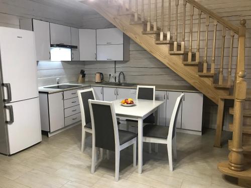 a kitchen with a table and chairs and a staircase at Villa Medova in Kosiv