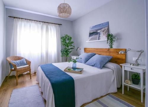 マラガにあるNuevo apartamento en Calle Salitre, Málaga Centroのベッドルーム1室(ベッド1台、椅子、窓付)