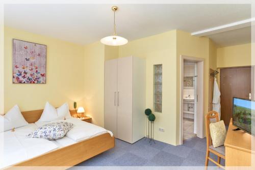 a bedroom with a large bed and a television at Gasthof BLASL Margaretha in Losenstein