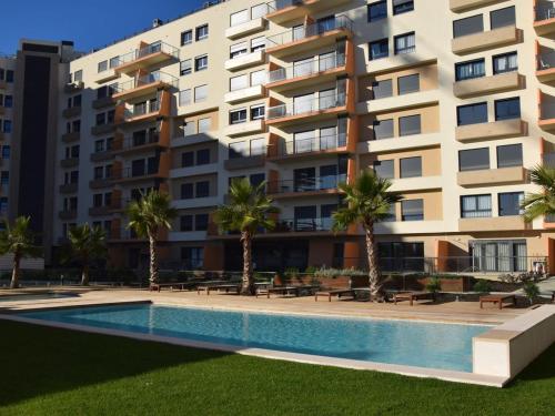 a swimming pool in front of a large apartment building at Apartment with view on Lisbon Tage & swimming pool in Seixal
