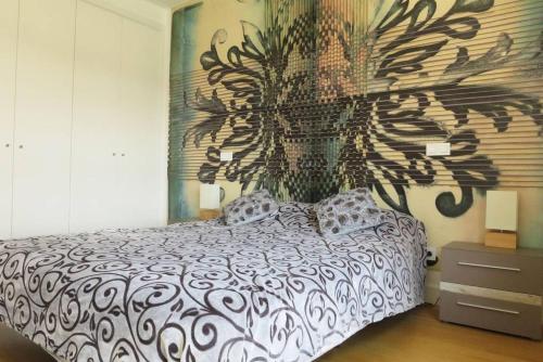 a bedroom with a bed with a painting on the wall at Apartment with view on Lisbon Tage & swimming pool in Seixal