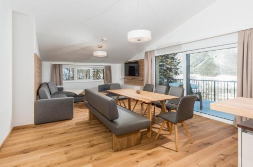 een eetkamer en een woonkamer met een tafel en stoelen bij Panorama Lodge Schladming in Schladming
