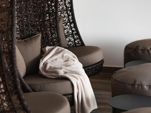 a room with two chairs and a blanket on a chair at Hotel Auszeit in Pertisau