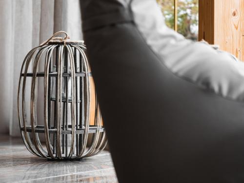 a person is sitting next to a bird cage at Hotel Auszeit in Pertisau