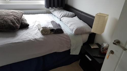 een slaapkamer met een bed met witte lakens en kussens bij Fully Equipped Modern 3 bedroom House in Bishops Stortford