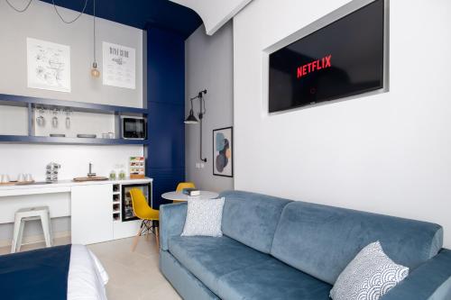 a living room with a blue couch and a kitchen at My Lodge Italy Centro Storico in Naples
