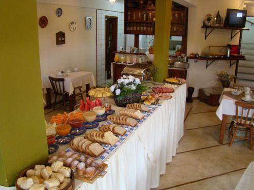 a long table with a buffet of food on it at Alpenhaus Pousada in Campos do Jordão