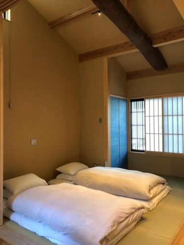 two beds in a room with two windows at Komatsu Residences in Kyoto