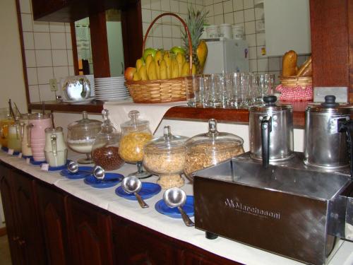 a kitchen counter with bowls and containers of food at Alpenhaus Pousada in Campos do Jordão