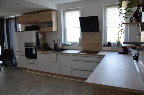 eine Küche mit weißen Schränken und einer Arbeitsplatte in der Unterkunft Ferienhaus May in Utzenhain