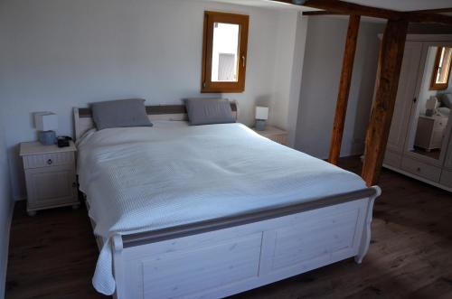 a large white bed in a bedroom with a window at Ferienhaus May in Utzenhain