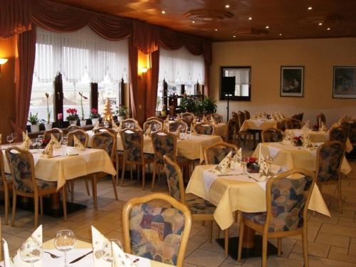 a dining room with tables and chairs with white table cloth at Hotel zur Waage in Bad Münstereifel