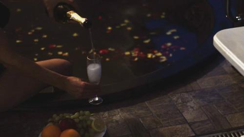 a person holding a glass of milk next to a plate of fruit at Villa Medova in Kosiv