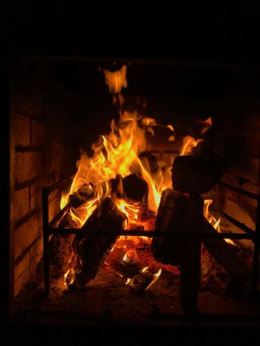 a fire in a fireplace with a person standing over it at Villa Medova in Kosiv