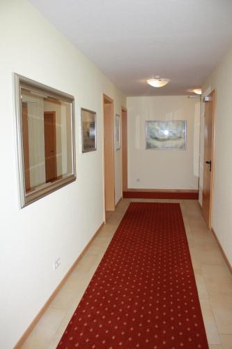 a hallway with a red carpet and a red rug at Hotel zur Waage in Bad Münstereifel