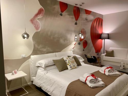 - une chambre dotée d'un lit blanc avec des ballons rouges sur le mur dans l'établissement Agorà B&B Urban Relais, à Canosa di Puglia